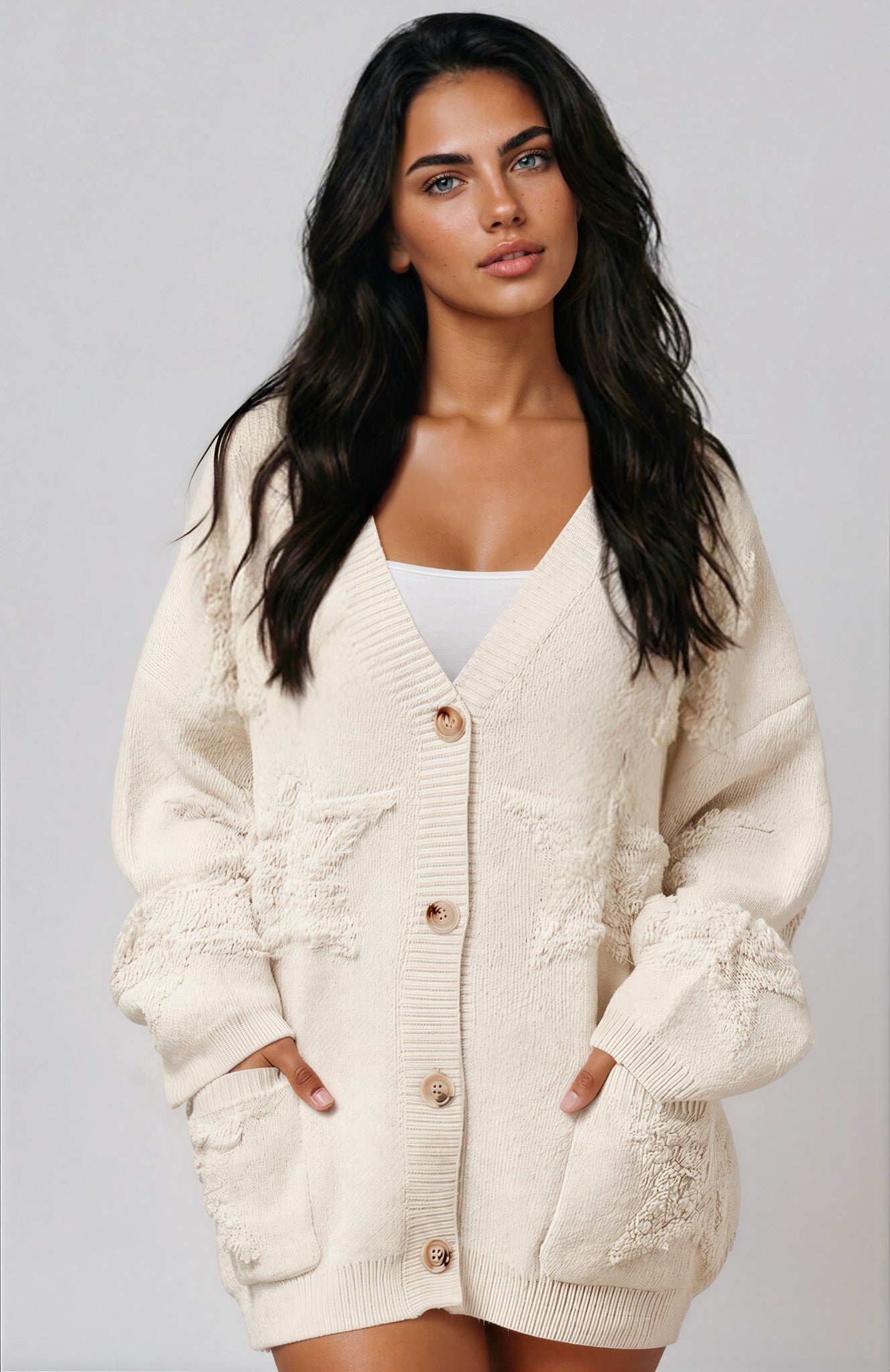 Woman wearing a cream cardigan  with star print against a plain background
