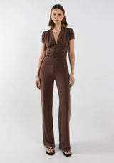 Woman wearing a brown vneck gathered top and pants set on a white background