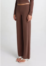 brown straight leg pants worn by a person on a white background