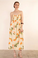 Woman wearing a floral dress against a plain background