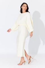 Side walking view of Aggie Knit Maxi Skirt in soft butter tone, showing its flattering ankle-length drape and stretchy knit fabric.