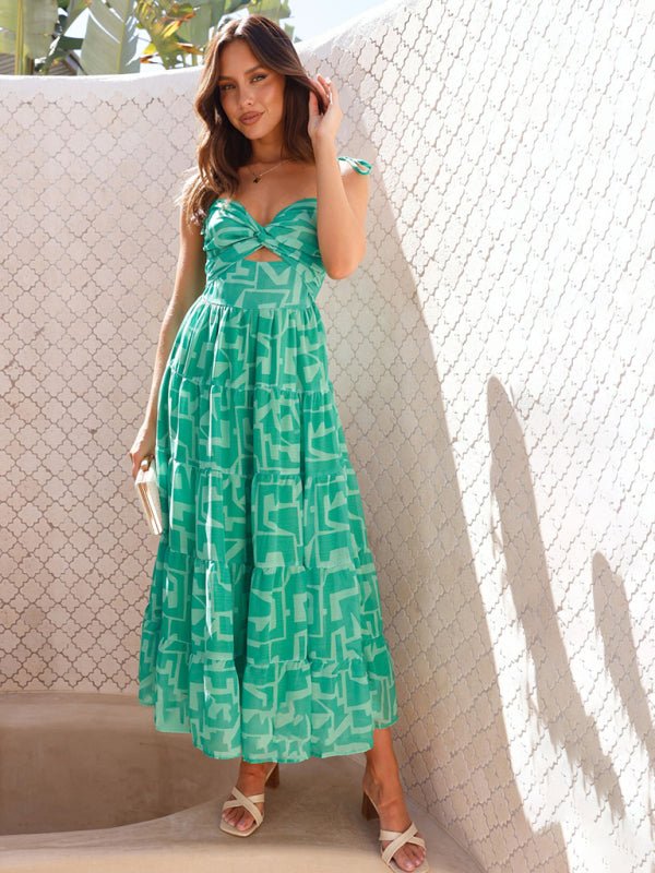 Woman wearing a green patterned dress standing against a textured wall.