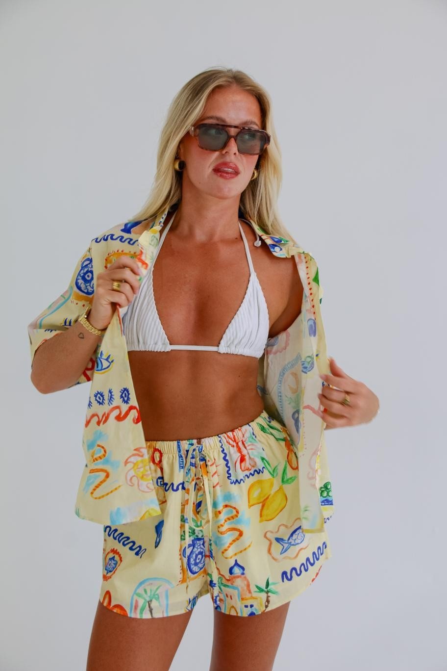 Woman wearing the Cairo Shirt & Shorts Set in colourful hand-painted print with open button-down shirt and matching shorts.