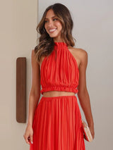 Side view of the Calista Skirt and Top Two Piece Set in red highlighting the flowing pleats.