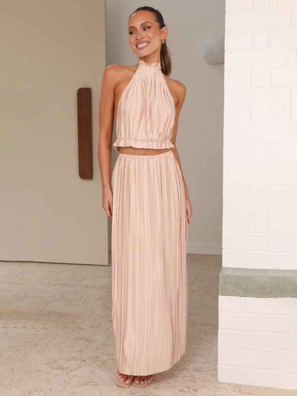 A model wearing the Calista Skirt and Top Two Piece Set in blush, showing the backless halter design.