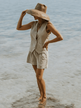 Model facing away, wearing the Carrie Sleeveless Vest and Cate Shorts set at the beach.