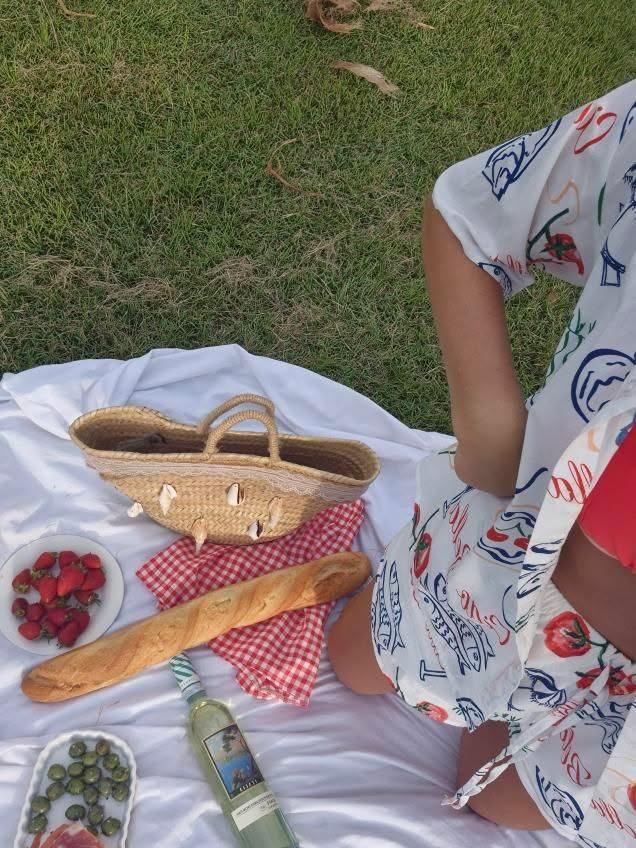 Picnic setting with model wearing Ciao Bella Top and Shorts Set styled casually on grass.