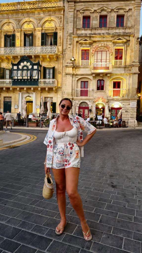 Woman wearing the Ciao Bella Top and Shorts Set in a city street at sunset.