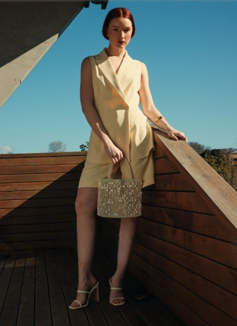 A model wearing the Clare Shorts Two Piece Set in cream, styled with the matching vest.