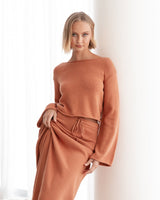 A model in the Cora Knit Set in burnt terracotta, showing the cropped top and coordinating maxi skirt.
