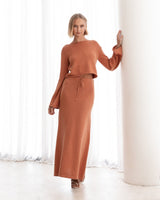 Front-facing image of the terracotta Cora Knit Set, styled with minimal accessories in a softly lit room.