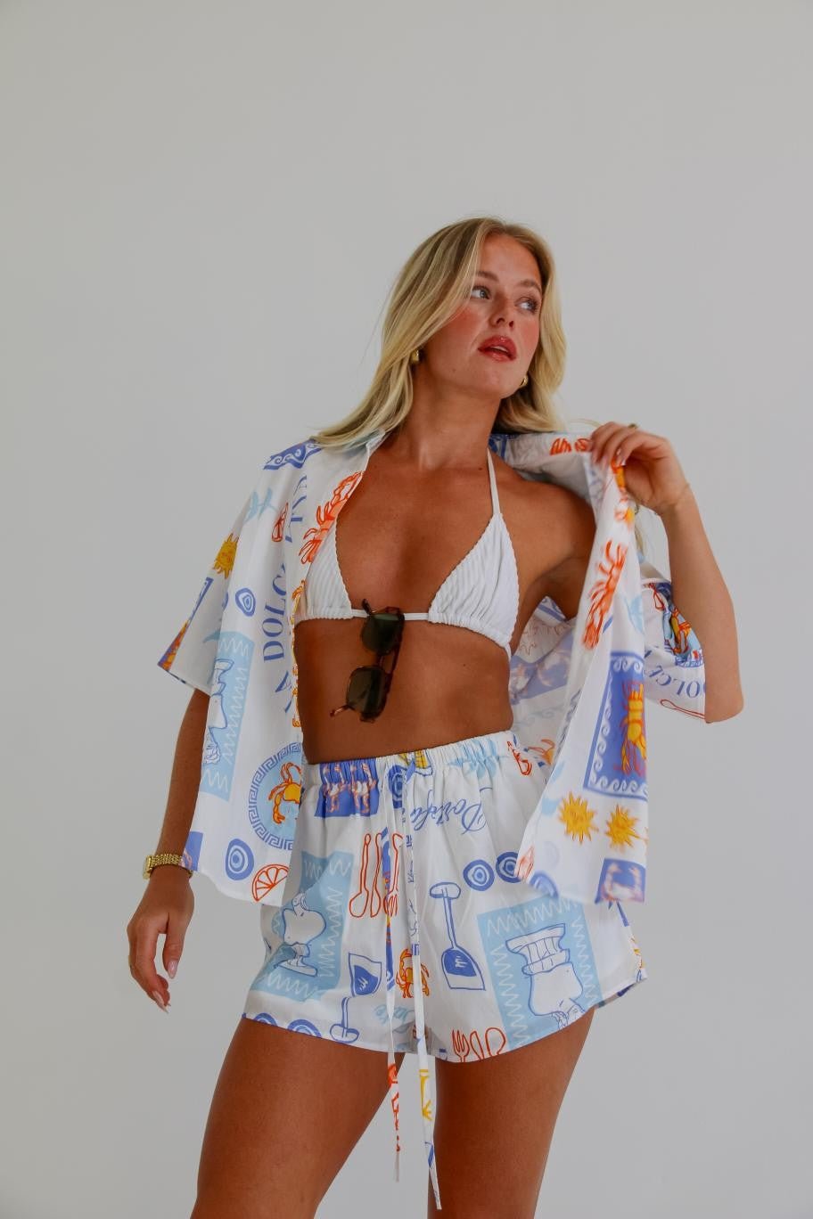 Woman wearing the Dinner Date Two Piece Set with oversized printed shirt and high-waisted shorts.