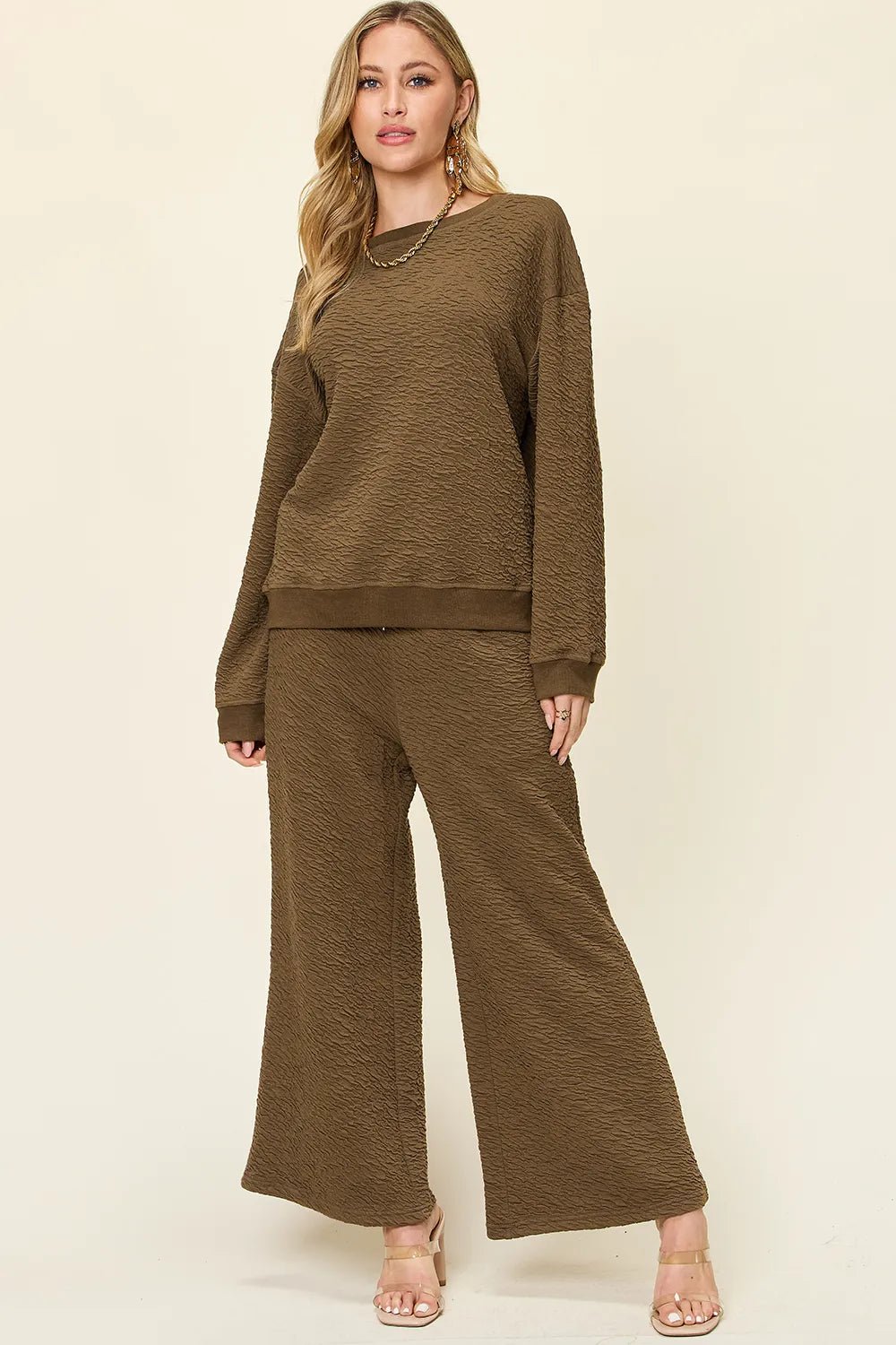 Woman wearing a brown  loungewear pants and top set on a beige background