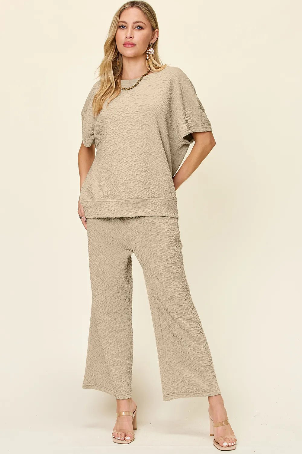 Woman wearing a beige loungewear pants and top set on a white background