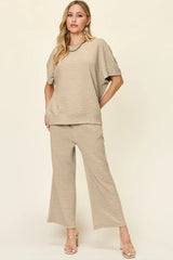 Woman wearing a beige loungewear pants and top set on a white background