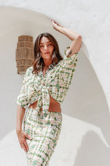 Model poses confidently with arm raised, showcasing the skirt's drape and the shirt's loose fit in natural light.