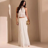 Woman wearing the Eden Two Piece Set in creamy white, standing in a sunlit studio