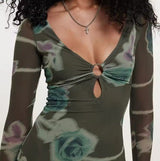 Green floral dress with long sleeves on a plain background