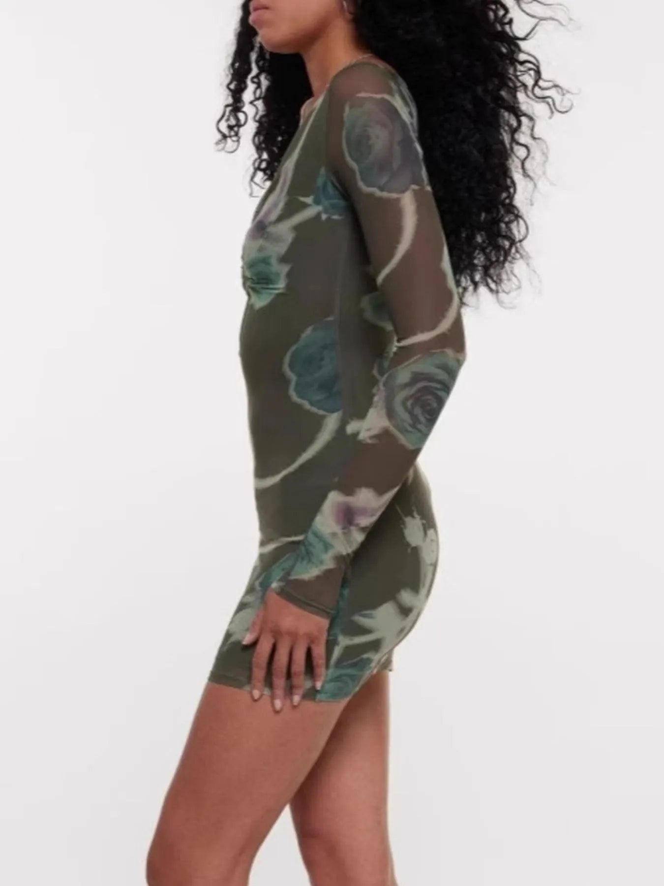 Woman wearing a green floral dress on a white background