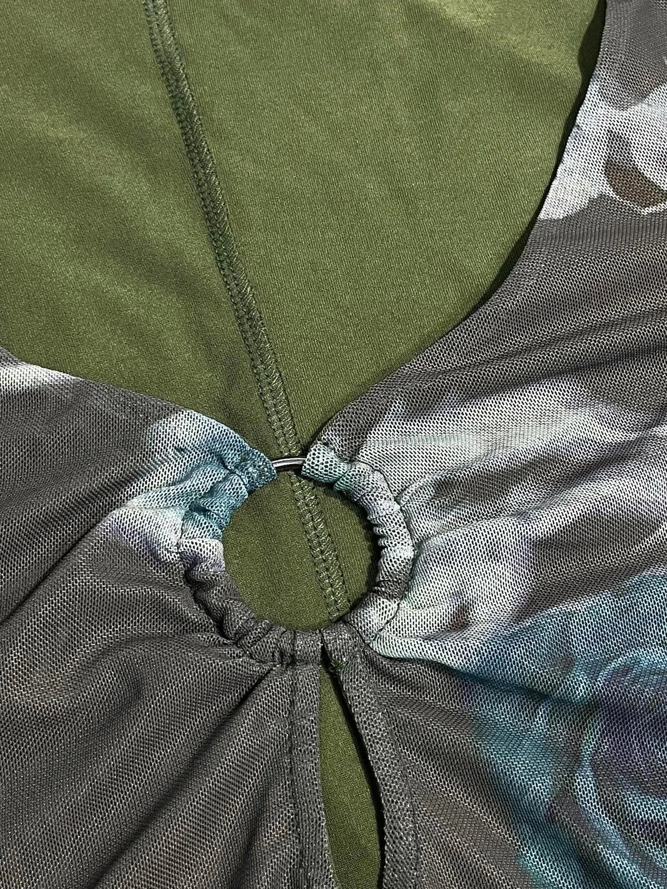 Close-up of a green and gray fabric with a knot, possibly from a bag or garment.