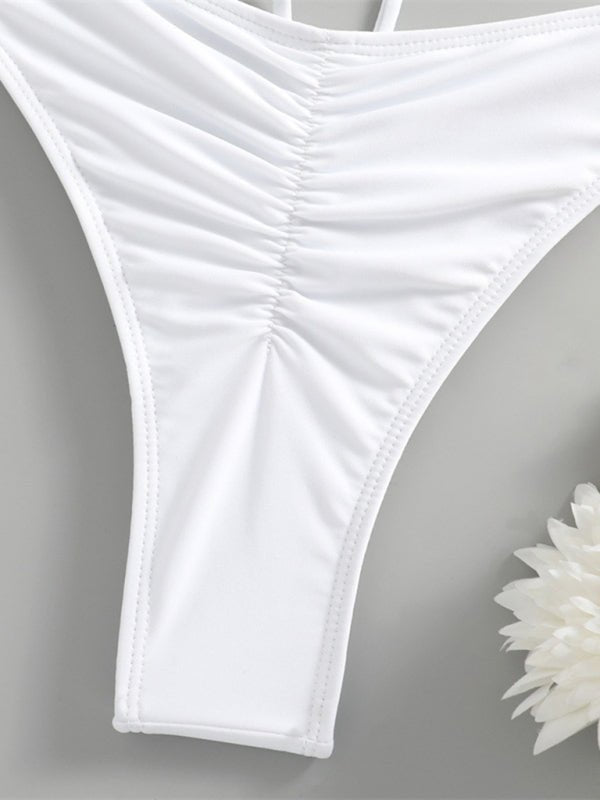 White thong on a gray background with a white flower.