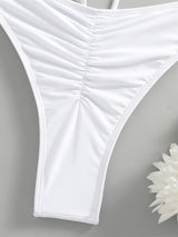 White thong on a gray background with a white flower.