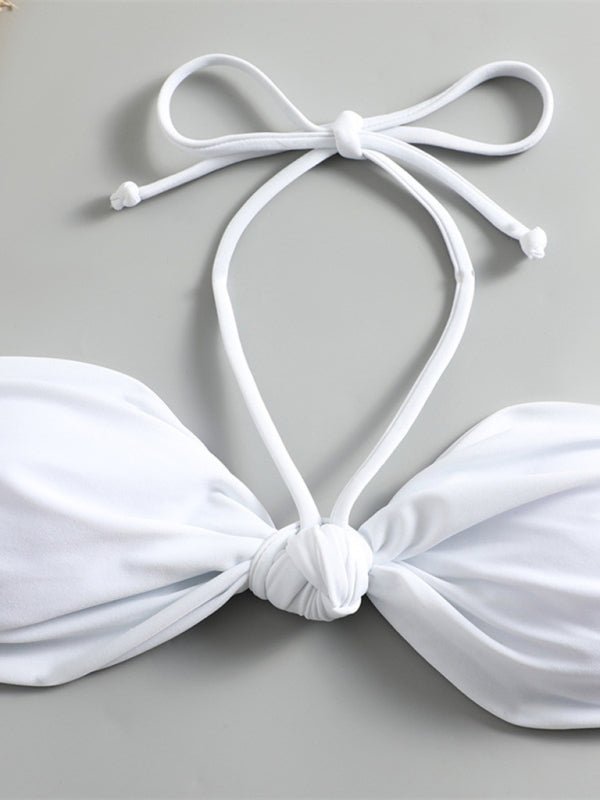 Close-up of the knot front detail and halterneck tie straps on the white bikini top.