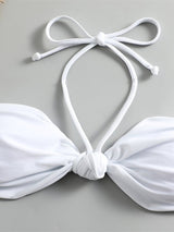 Close-up of the knot front detail and halterneck tie straps on the white bikini top.