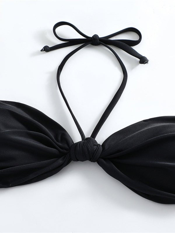 Black bikini top with a bow design on a white background