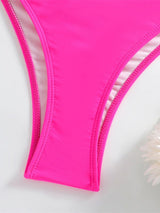 Close-up of a bright pink bikini bottom on a light gray background