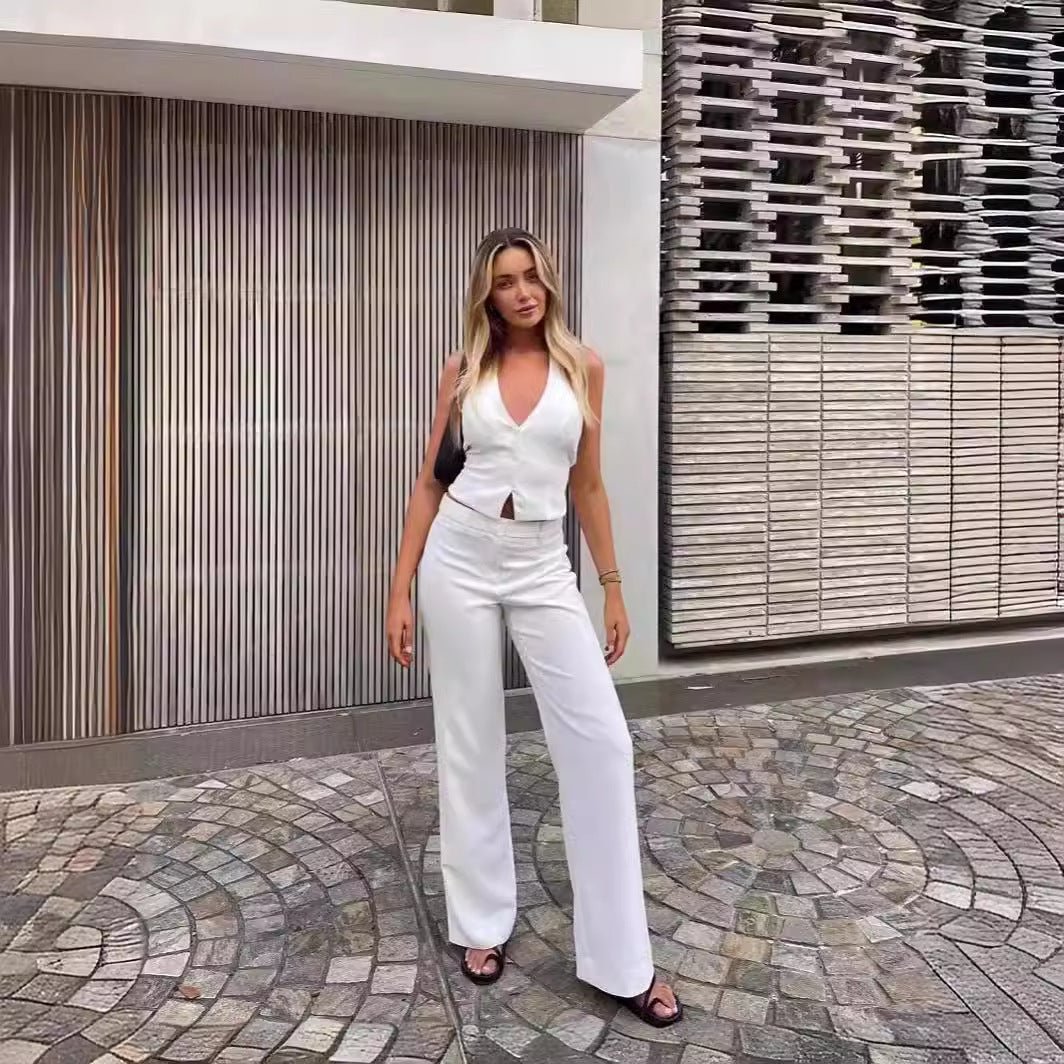 Woman wearing the white Flair Two Piece Set, standing on cobblestone street