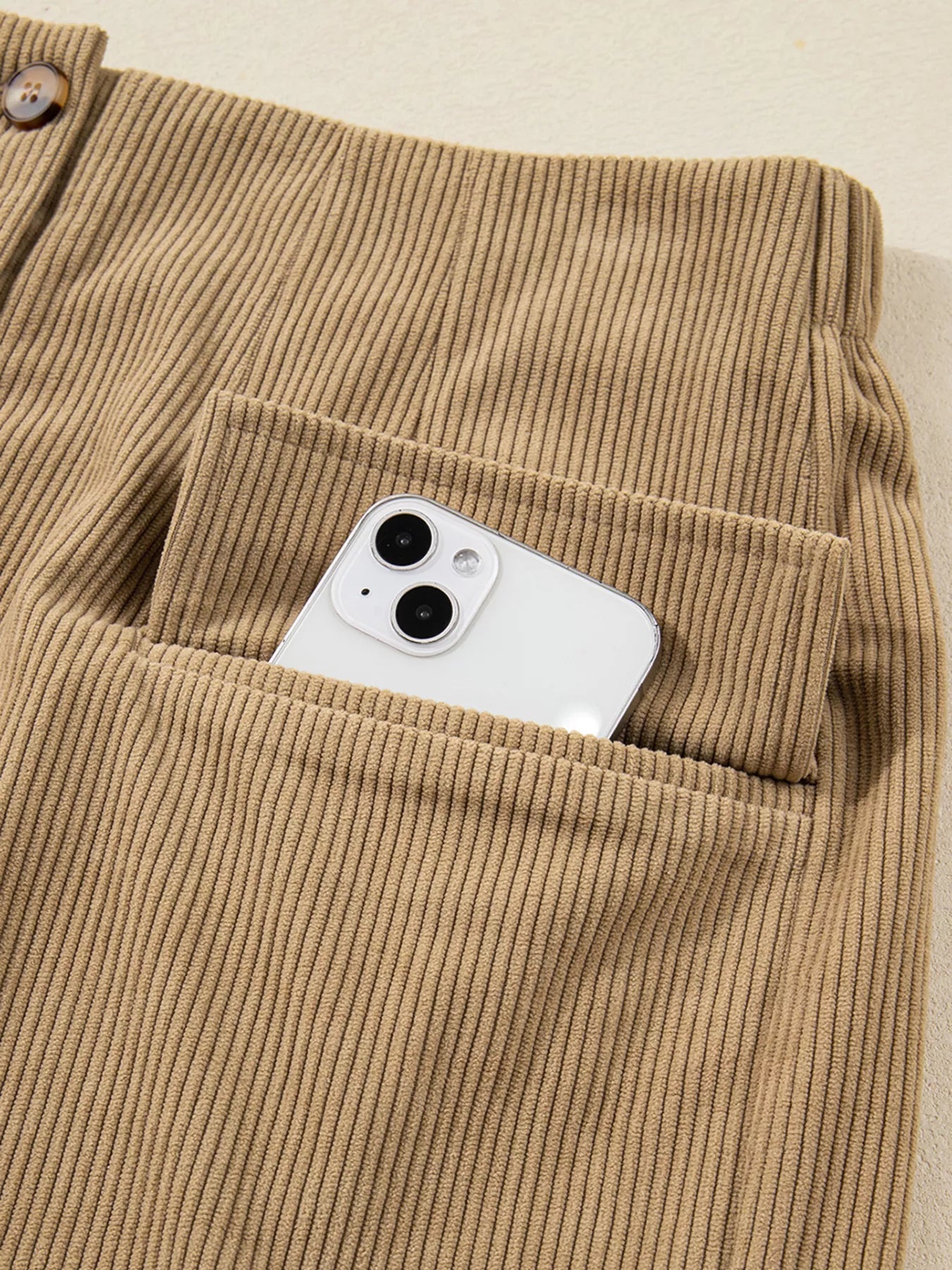 Functional pocket holding smartphone on corduroy skirt
