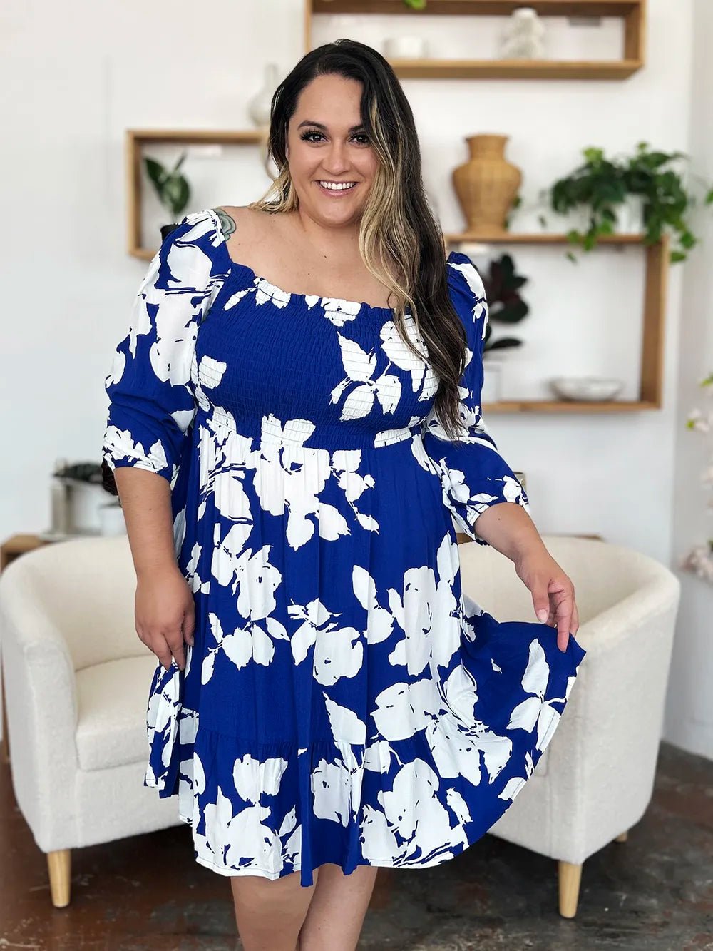 Woman wearing a blue floral dress in a home setting