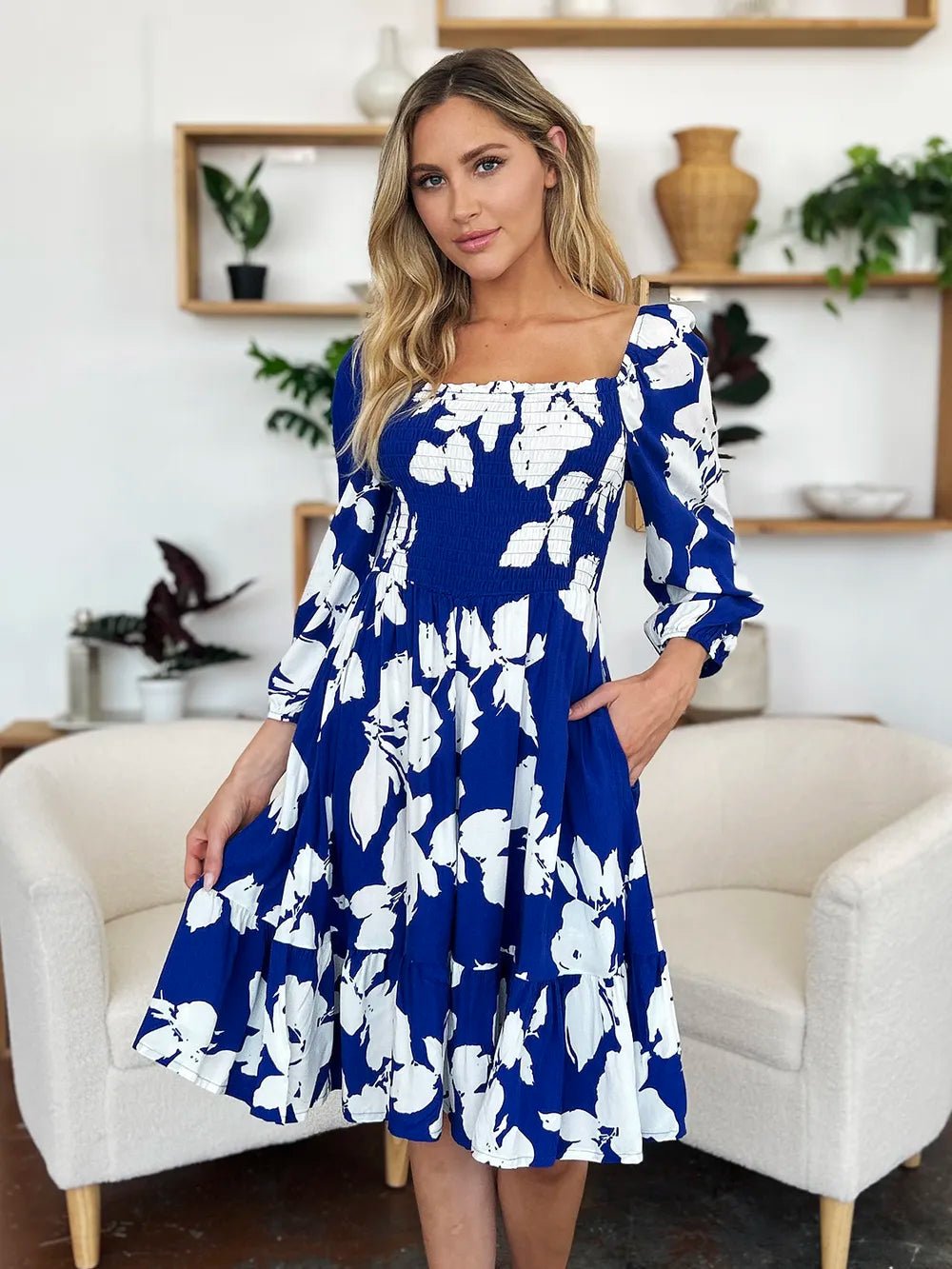 Woman wearing a blue floral dress in a living room setting