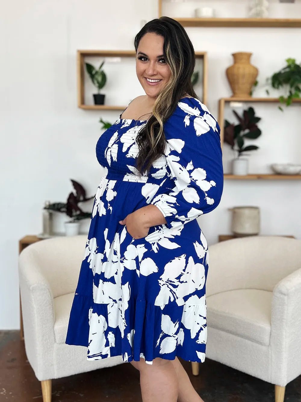 Woman wearing a blue floral dress in a living room setting