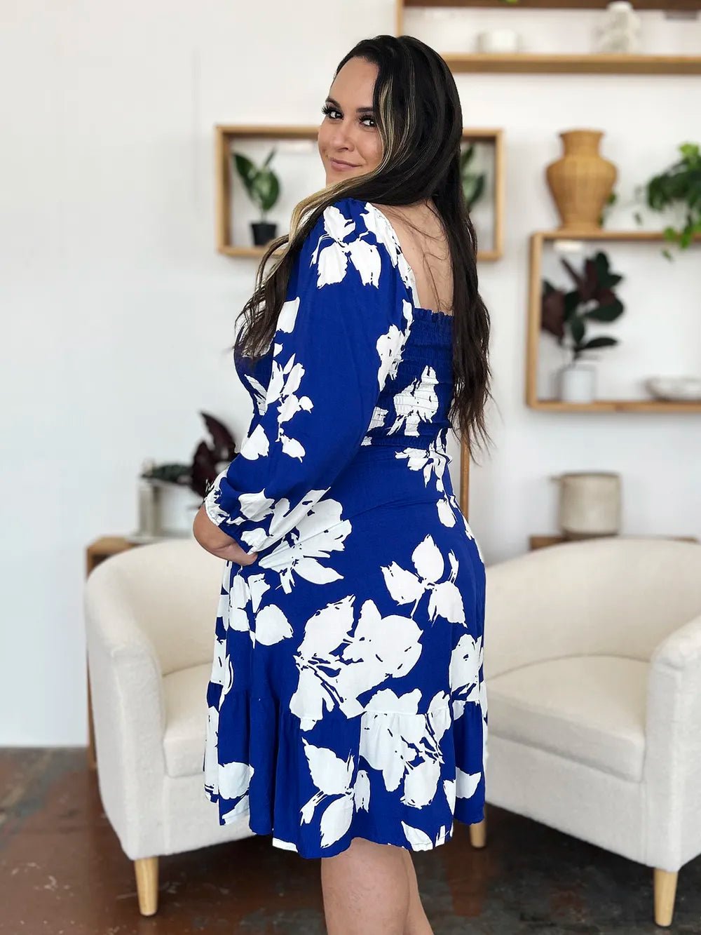 Woman wearing a blue floral dress in a living room setting