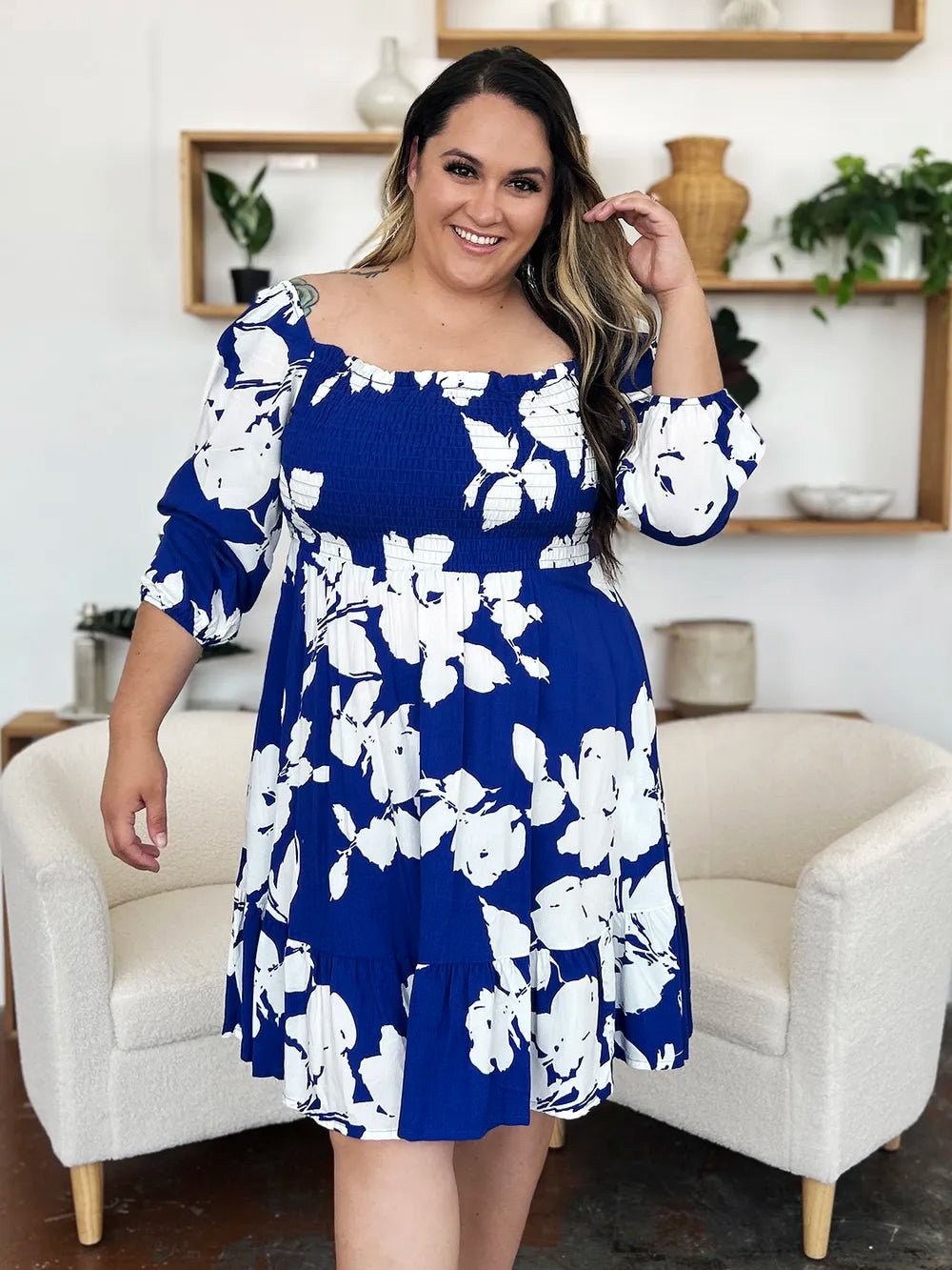 Woman wearing a blue floral dress in a living room setting
