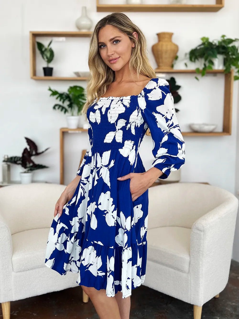 Woman wearing a blue floral dress in a living room setting