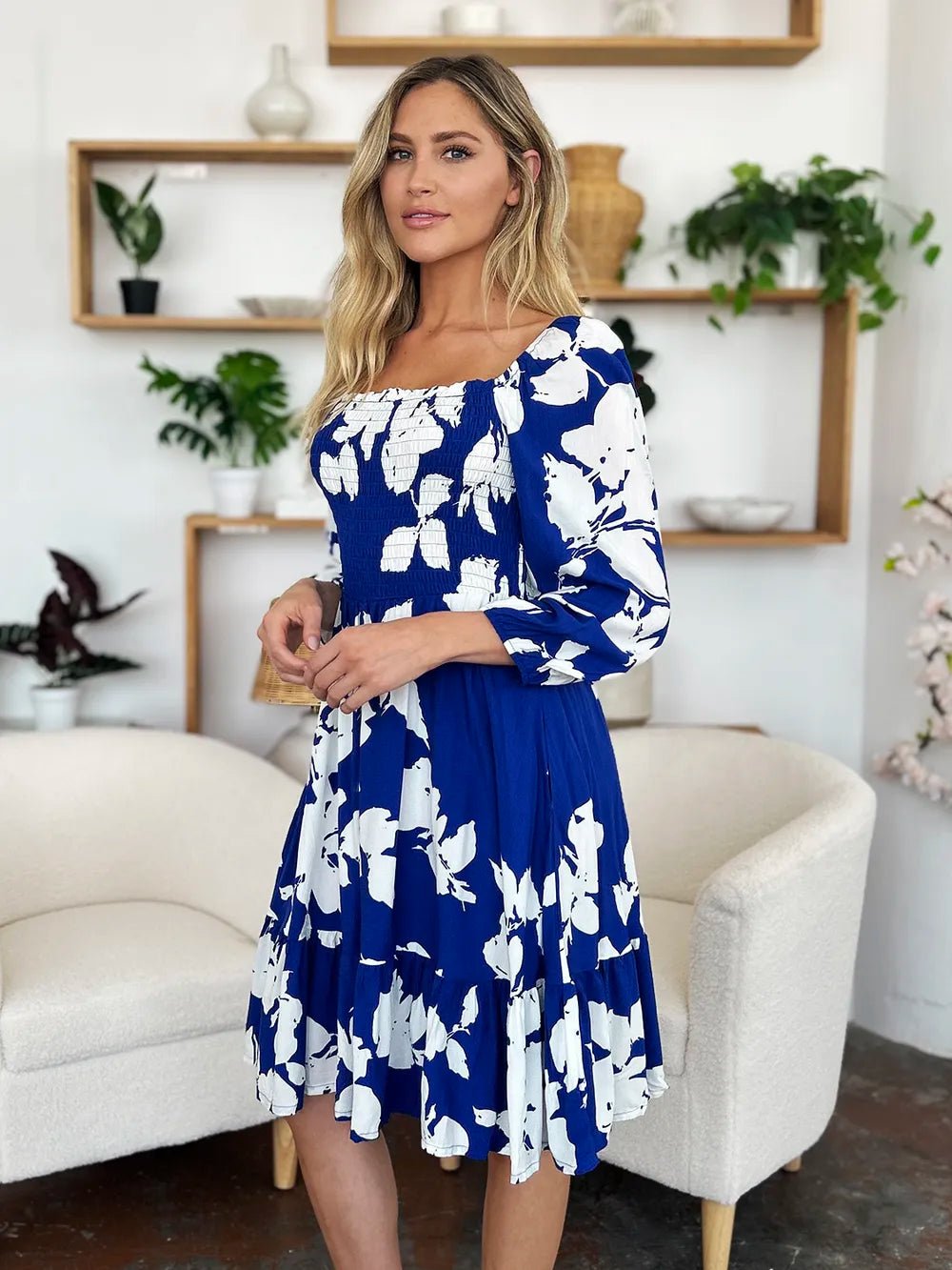 Woman wearing a blue floral dress in a home setting