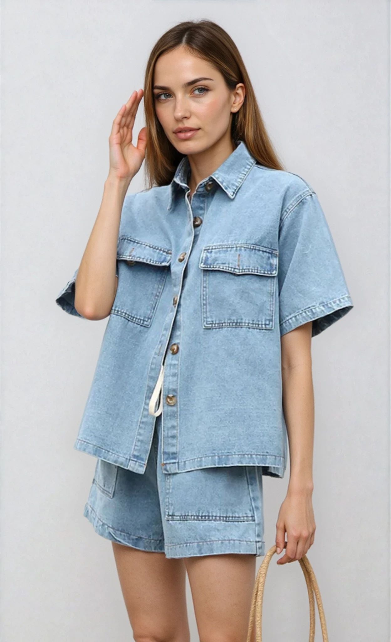 Front-facing image of the light blue Indigo Denim Two Piece Set styled casually with a tan shoulder bag.