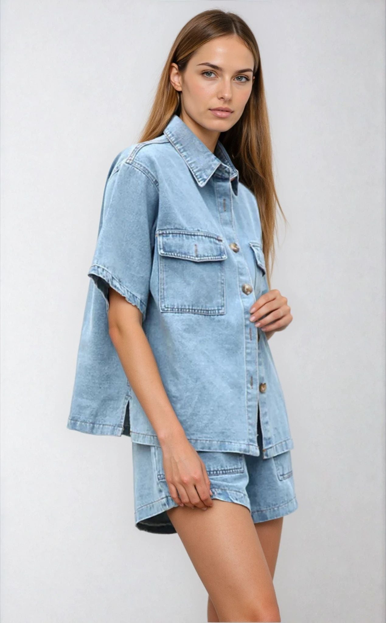 Model slightly angled in the light blue denim two piece set, showing shirt button detail and casual shorts fit.
