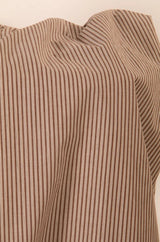 Close-up of a sleeveless brown and white striped top on a beige background
