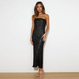 Woman wearing a black strapless dress against a white background