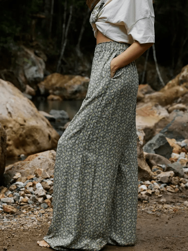Person wearing a long floral skirt standing in a rocky outdoor setting