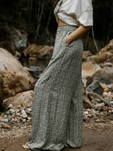 Person wearing a long floral skirt standing in a rocky outdoor setting