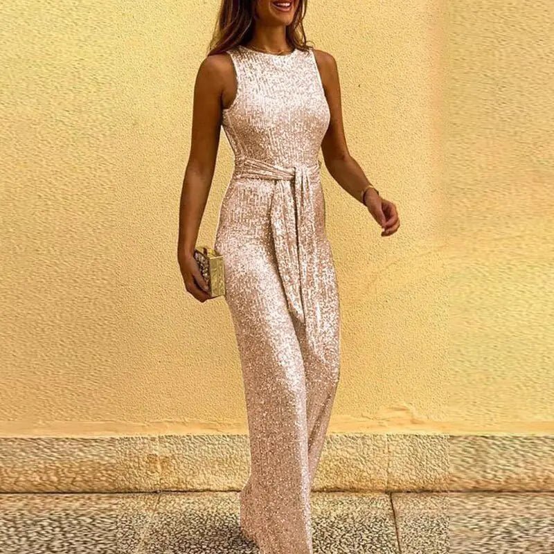 Marilyn Sequin Jumpsuit in Champagne Gold, model walking against a warm yellow backdrop