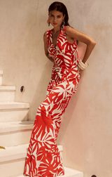 Model in red co-ord set with bold print, posing on staircase.
