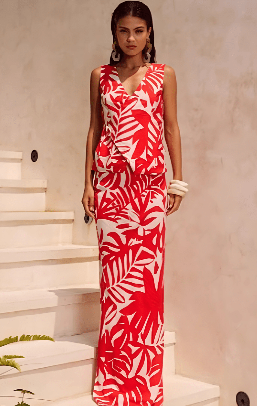 A model wearing the Matelo Vest and Maxi Skirt Two Piece Set in red, featuring a tropical white leaf print.