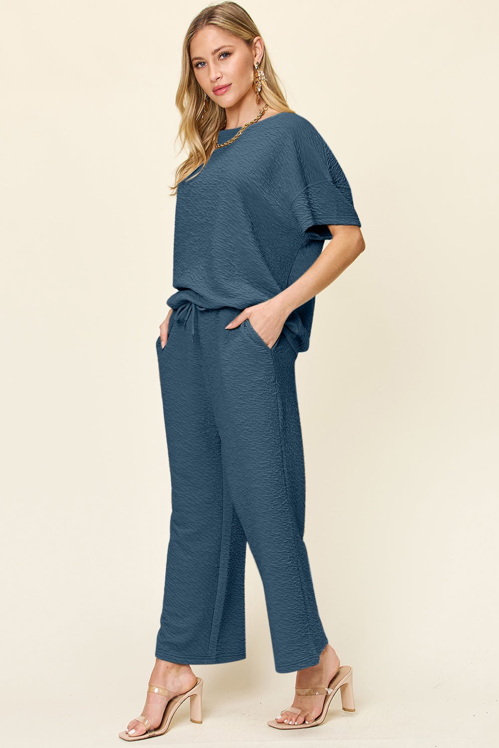 Woman wearing a blue jumpsuit on a beige background