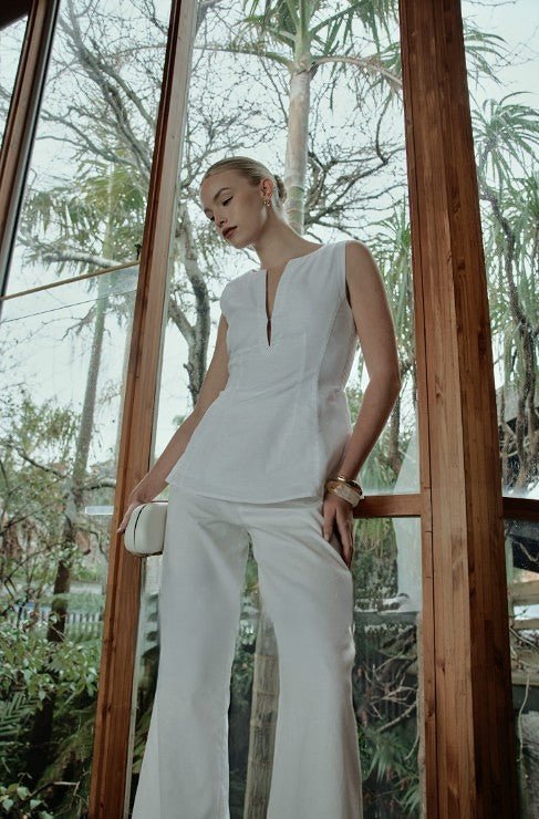 The Mercer Sleeveless Top styled with matching white pants in an outdoor setting.